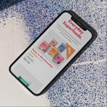 Everyday superfoods website on an iPhone on a white and blue background.
