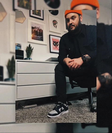 Image of a man wearing black clothes and a orange hat.
