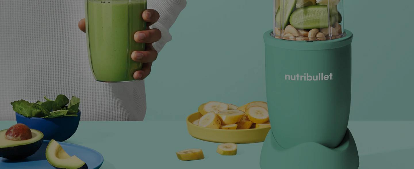 nutribullet blender with fruit and nutes on a green background.