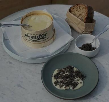 Plates of food and bread on a white table.