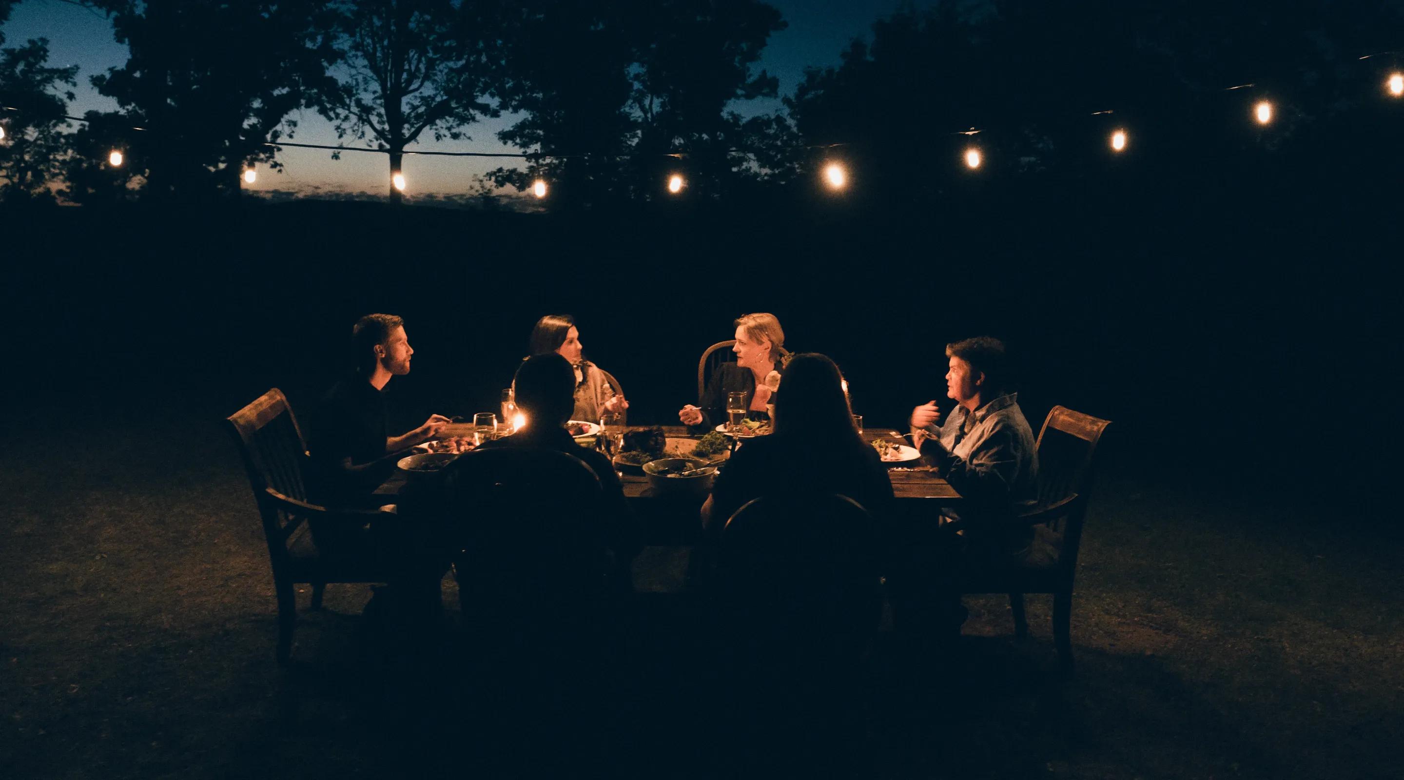 Image of people having sunset dinner outdoors.